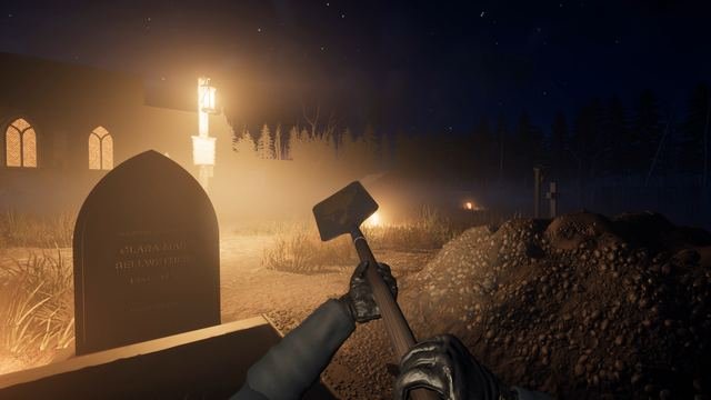 In-game, first person at St. Brannoc's: gloved hands on the shovel in an open grave beside Clara Mae Bellwether's headstone, the spoil heaped high and the church windows lit behind.
